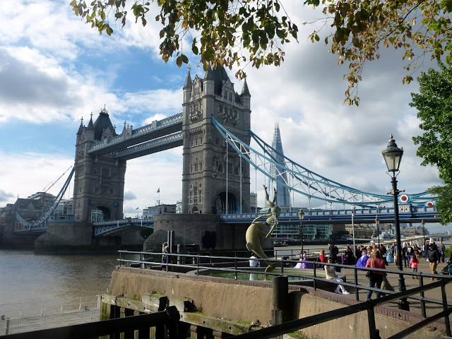 view of a bridge with 2 tall towers topped with a grey pointy roof and an upper bridge spanning the two as well as a lower one. 