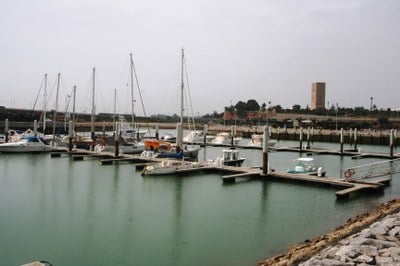 flat marina basin with floating pontoons and a few yachts moored up