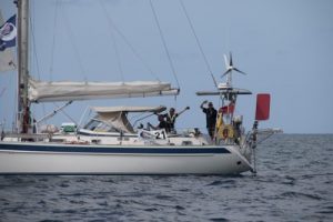 Enthusiastic competitors wave to the camera on one of the ARC race boats getting ready to cross the start line