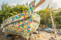 Boat on the beach made of coloured discarded flip-flops