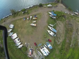 aerial view of the boatyard at Hiva Oa with monohulls and catamarans parked on dry standing/grass area