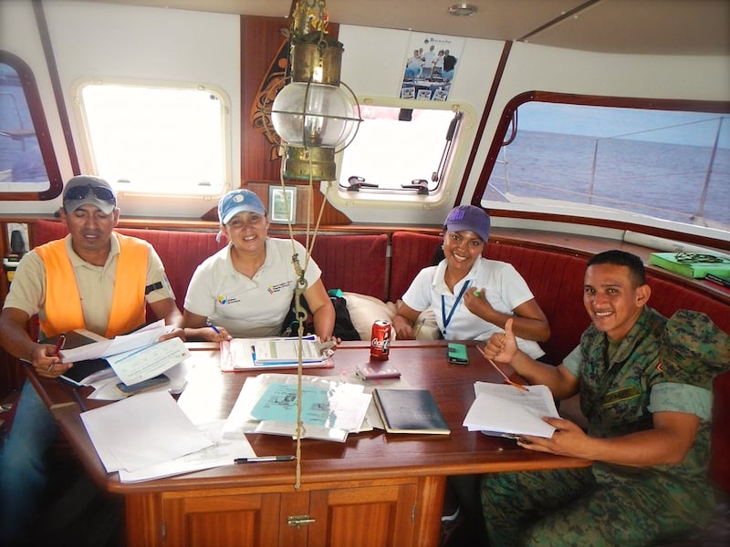 four clearance officials sitting around the saloon table on board yacht bonobo