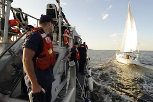 Coast Guard Vessel approaching sailboat for boarding.