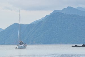 yacht at anchor with mountains behind