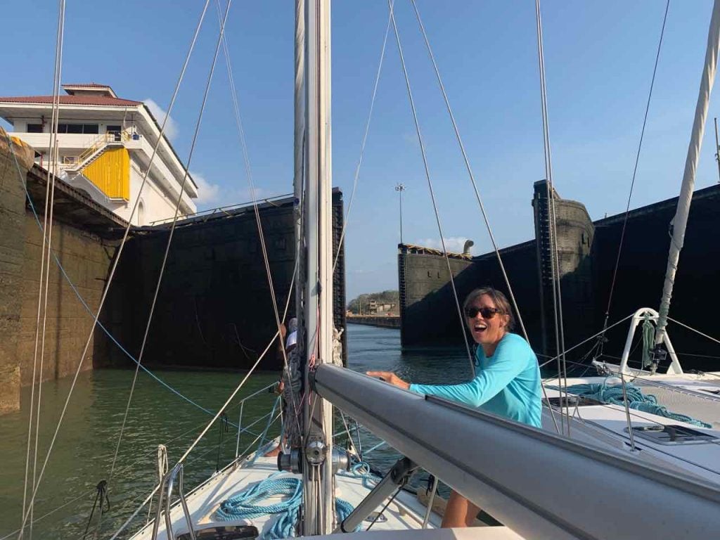 jane on deck with the lock gates of the panama canal behind her just beginning to open