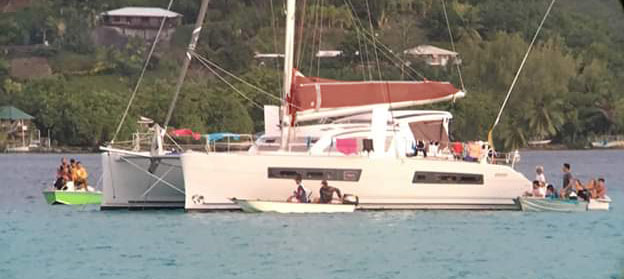 catamaran at anchor surrounding by several dinghies
