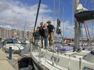 4 people standing on the foredeck of a boat with their arms around each other