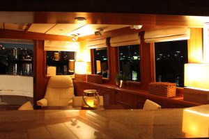 warmly lit interior of the boat with mahogany wood and cream leather upholstery