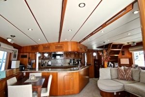 warmly lit interior of the boat with mahogany wood and cream leather upholstery