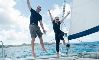 man and woman jumping on catamaran trampolines