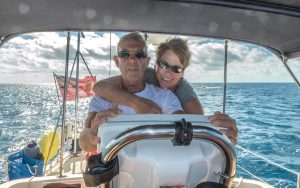 man and woman at the helm of a yacht