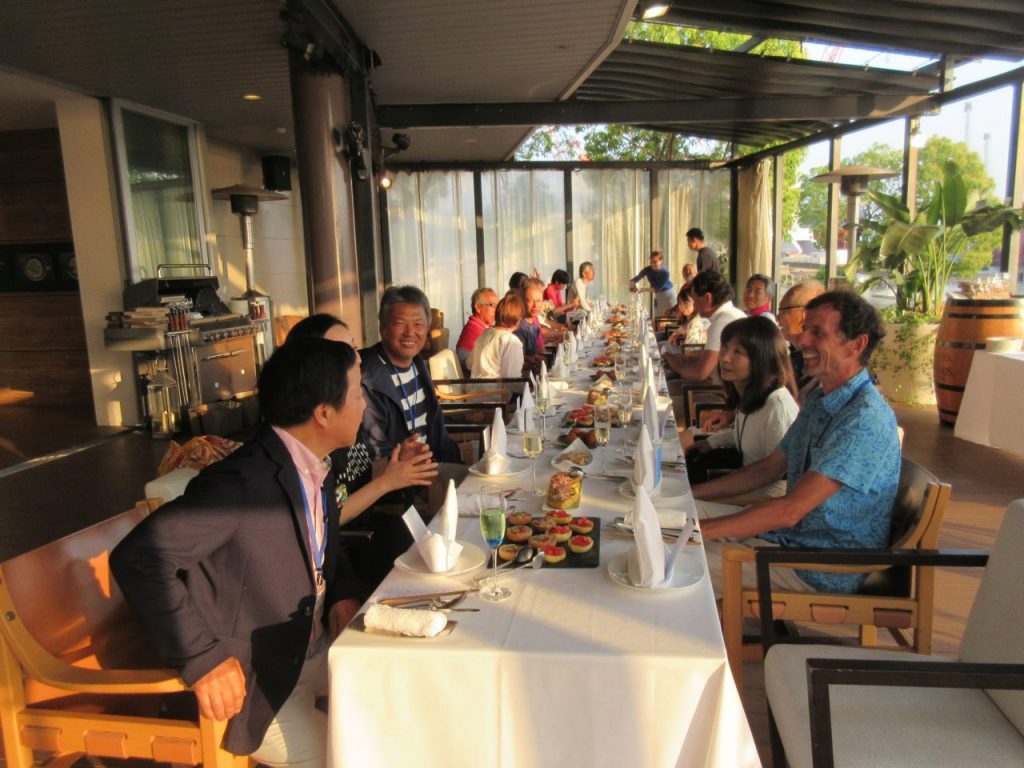 People sitting around a long white table for a meal.