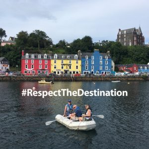 People on a dinghy with colourful buildings in the background