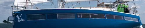 Side view of yacht showing solar panels in the window spaces.
