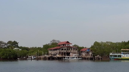 Three storey hotel on the shore looking from the water.